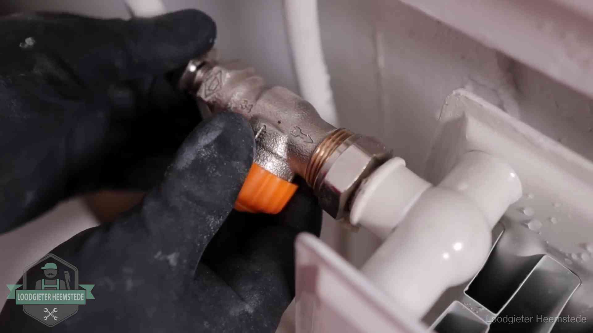 Thermostaatkraan wordt gemonteerd op een radiator in Heemstede voor het stookseizoen