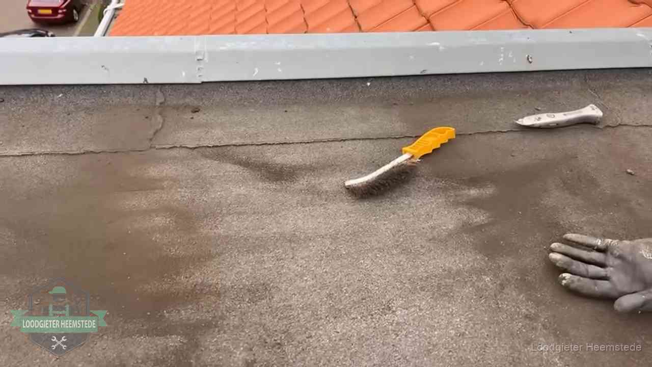 Dakdekker bereidt een bitumen plat dak voor op reparatie bij de daktrim in Heemstede