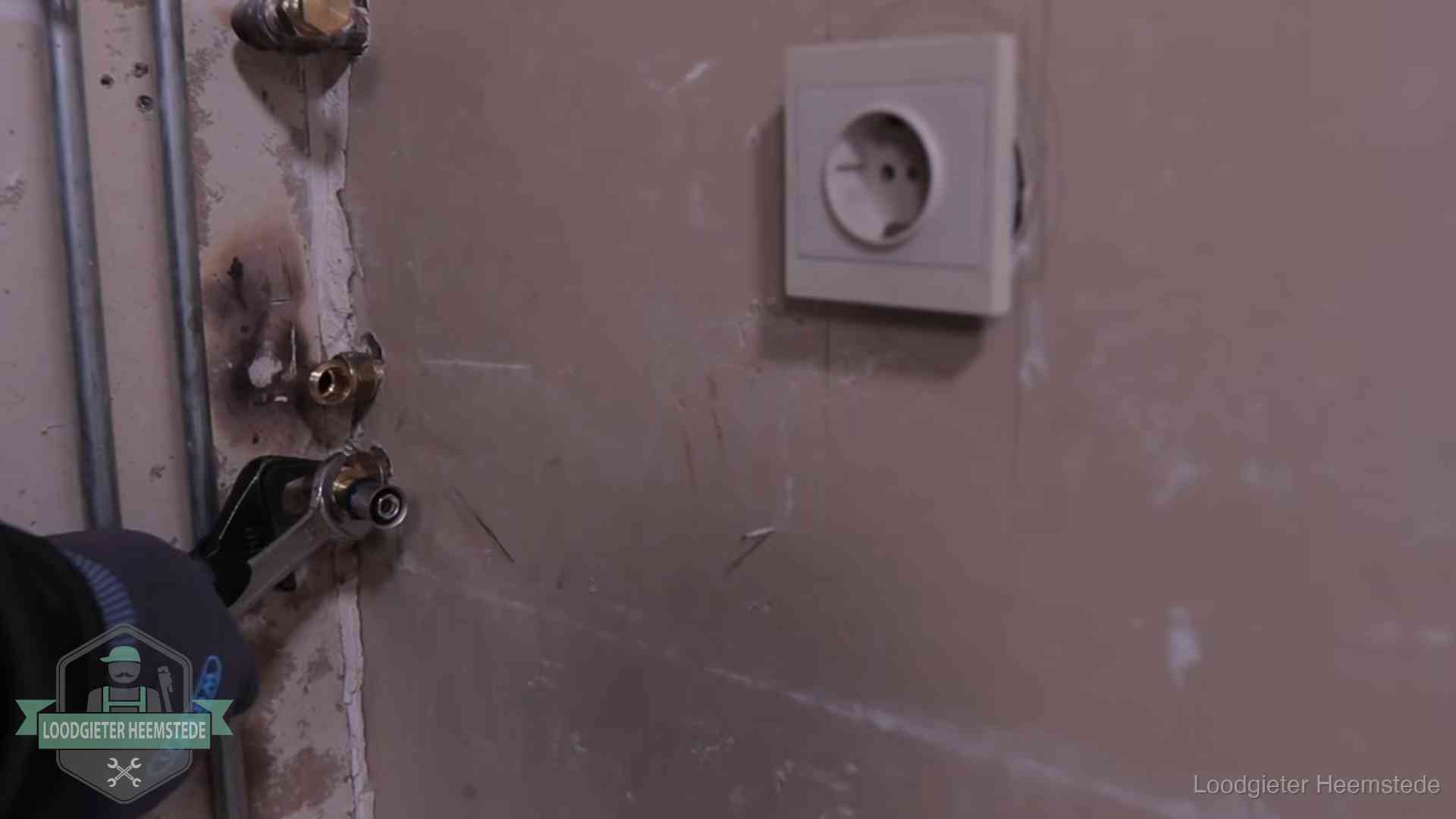 Monteur draait een perskoppeling vast op een leidingaansluiting in Heemstede