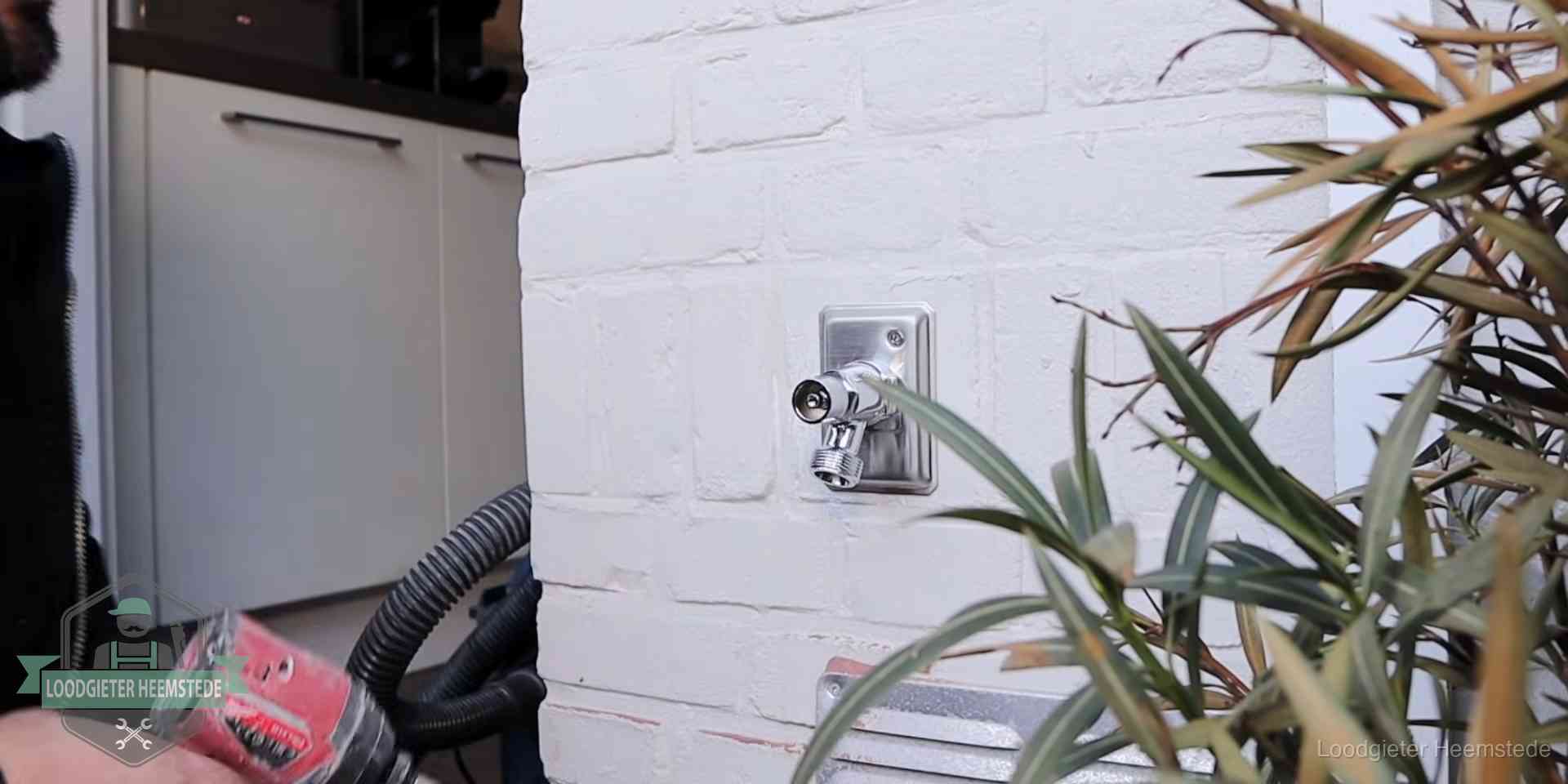 Chromen kraan op een muurplaat bij een woning in Heemstede, dichtdraaien is stap een van de lektest
