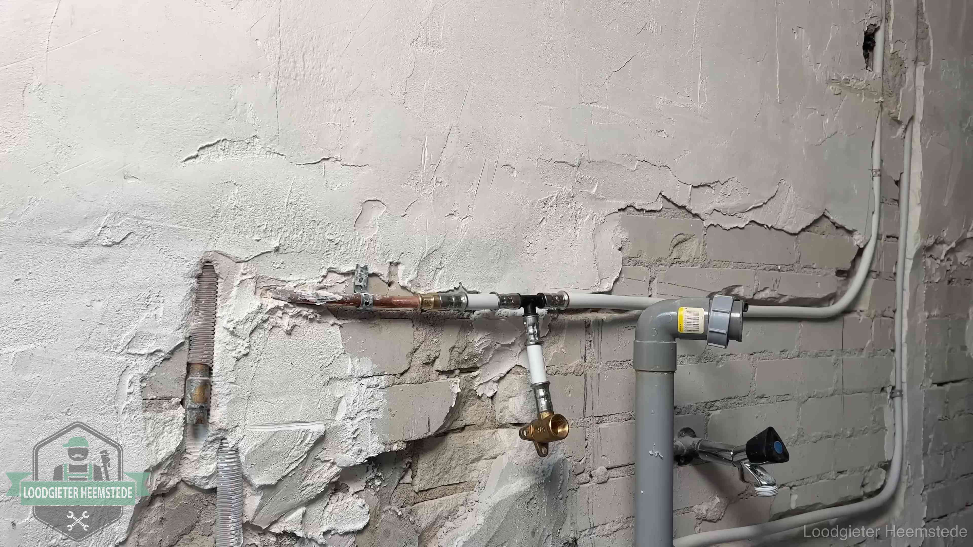 Nieuw leidingwerk naast een oud verroest leidingrestant in een woning in Heemstede