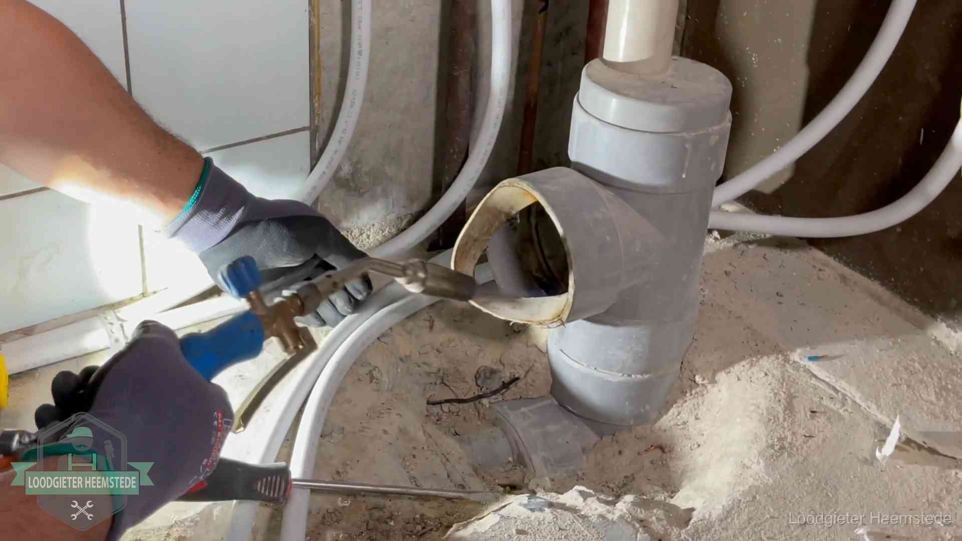 Loodgieter werkt met brander en messing kraanwerk aan leidingen in Heemstede