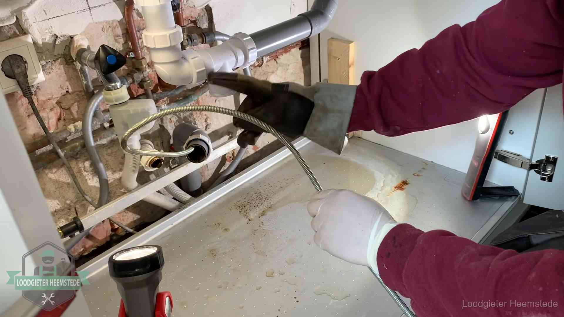 Spiraal of hogedruk in Heemstede Ontstoppingsveer gaat in een geopende sifonaansluiting onder het aanrecht in Heemstede
