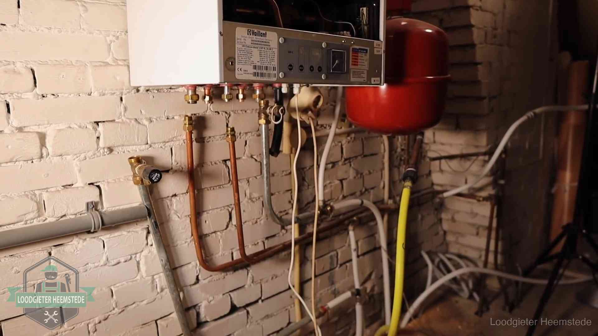 Verouderde cv-ketel met een wirwar van oude leidingen in een woning in Heemstede