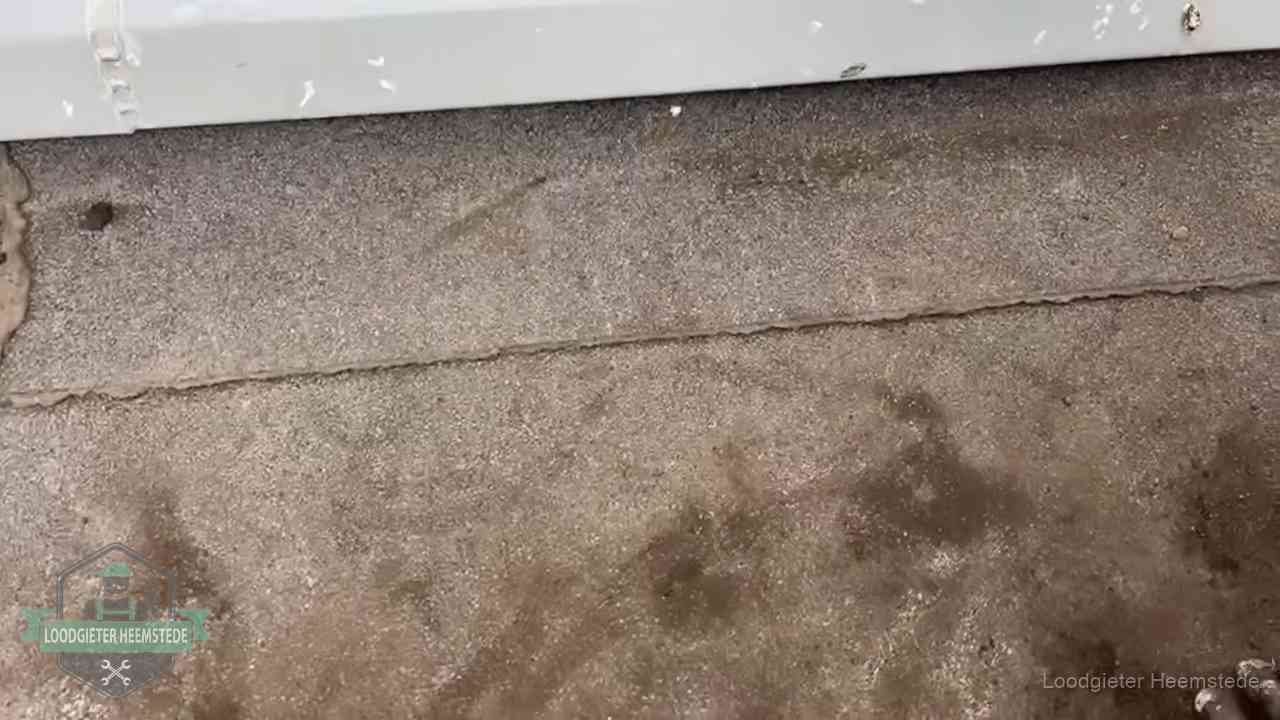 Vochtplekken bij de naad van een plat dak na aanhoudende regen in Heemstede