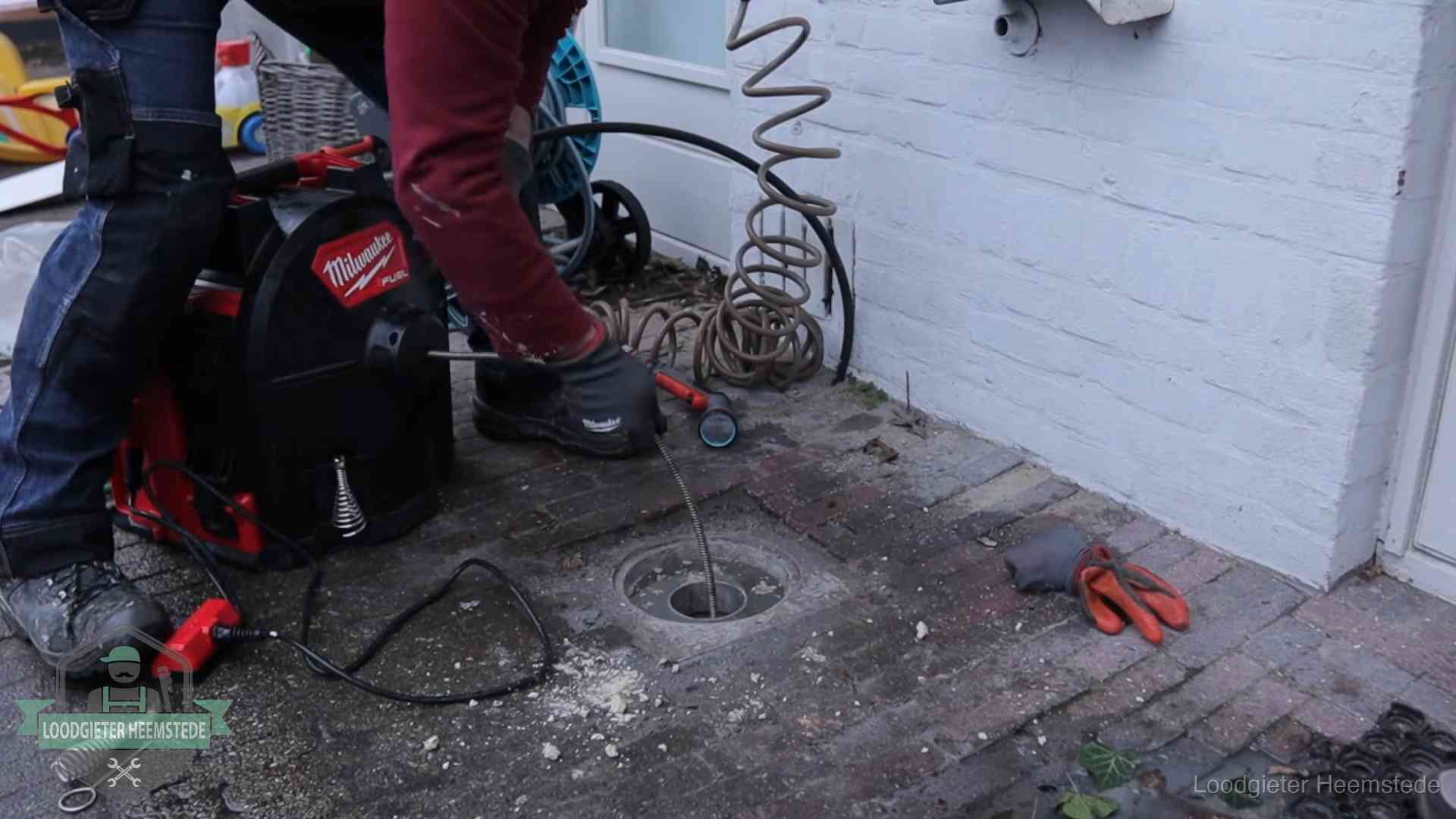 Prijs van een rioolontstopping in Heemstede Spiraalmachine bij een ontstoppingsputje in de bestrating in Heemstede