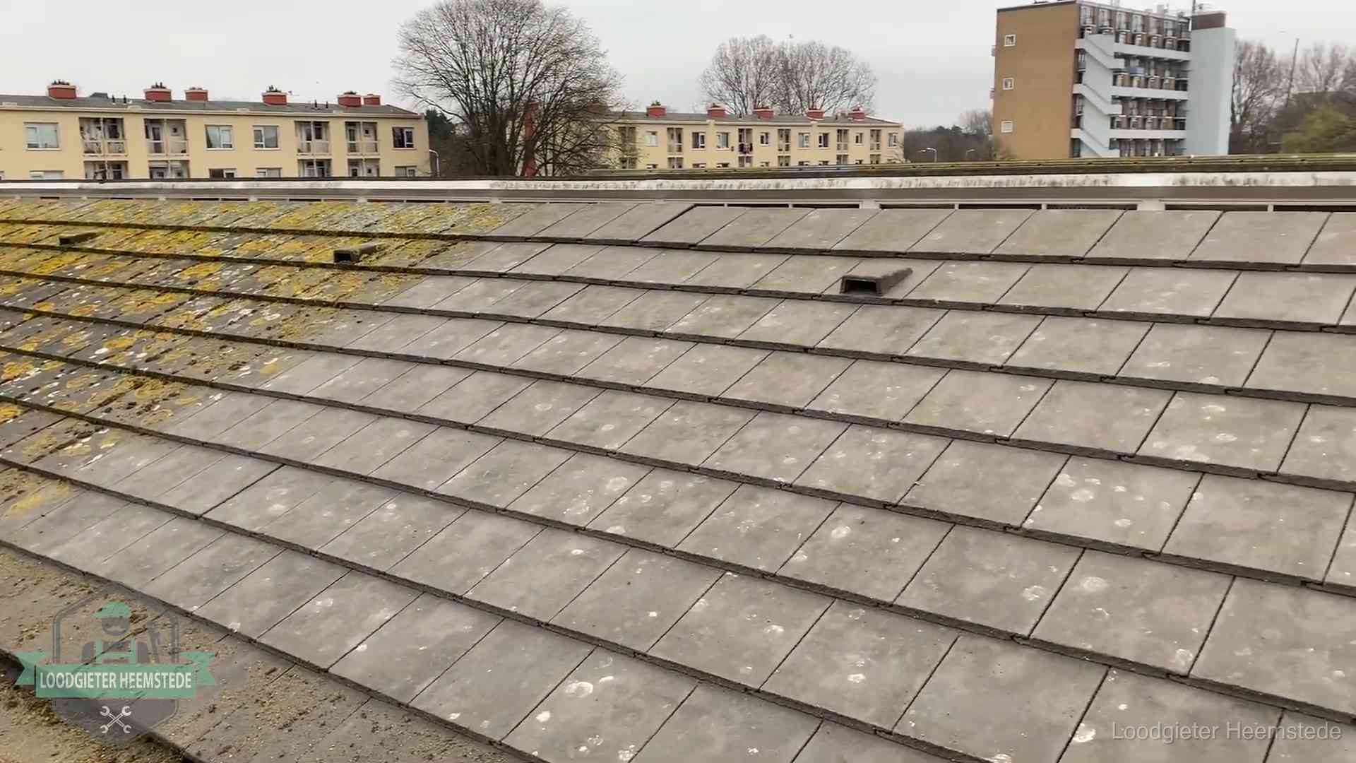 Schuin dak met betonpannen vol mos in Heemstede, een risico op lekkage bij de pannen