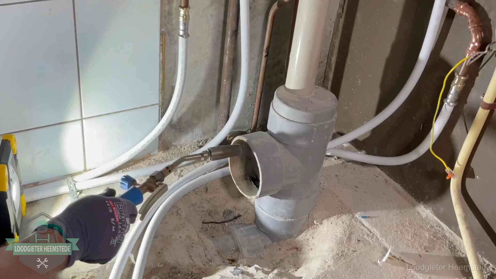 Verstopping in een huurwoning in Heemstede Loodgieter werkt aan leidingen bij de pvc-standleiding van een huurwoning in Heemstede