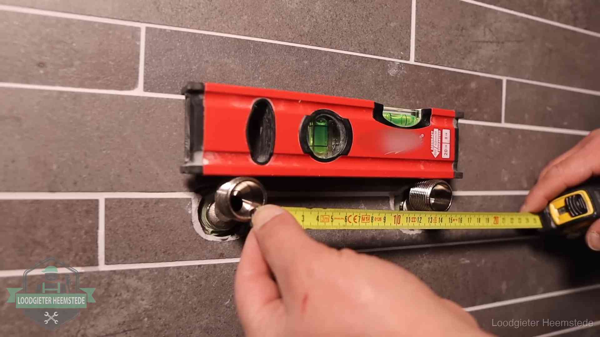 Waterpas en duimstok bij kraan-aansluitpunten in een badkamer in Heemstede