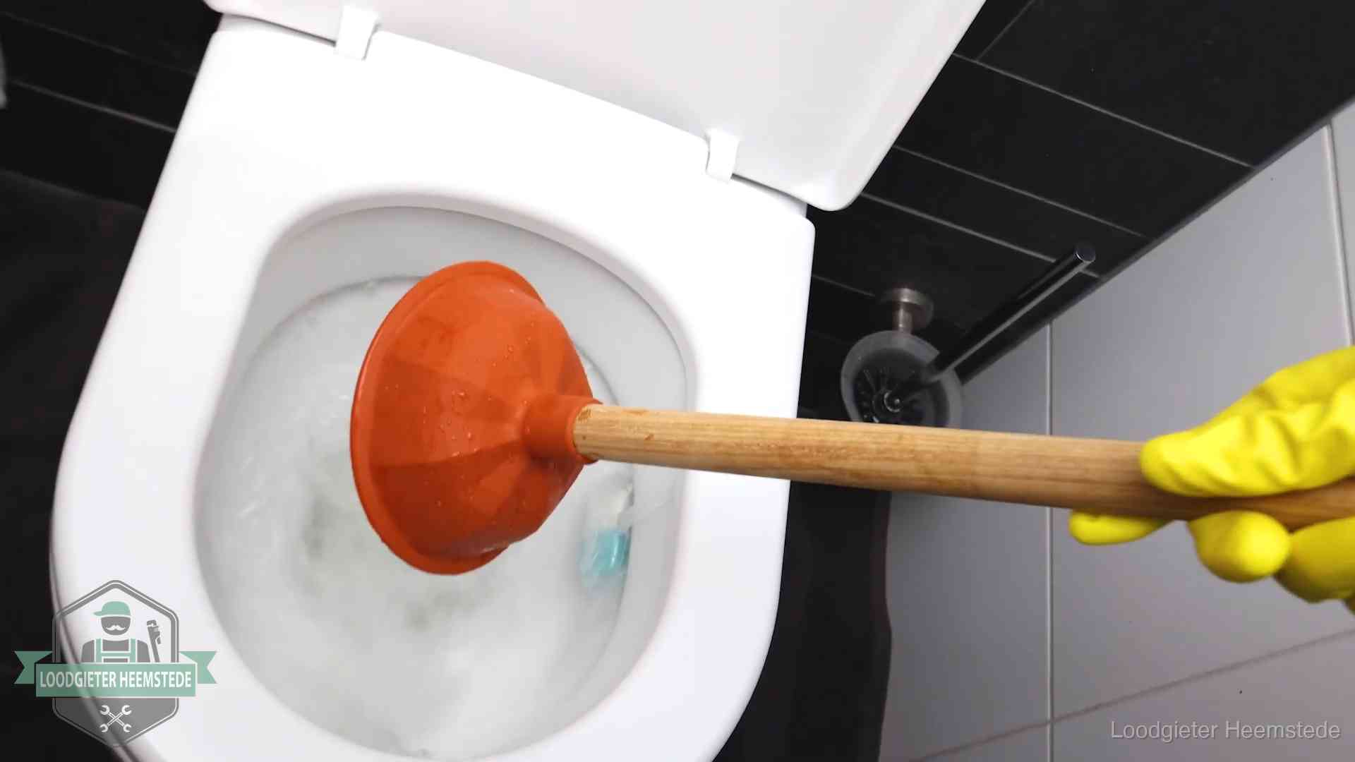 Wc ontstoppen met de plopper in Heemstede Plopper wordt in de wc-pot gedrukt bij het ontstoppen van een toilet in Heemstede